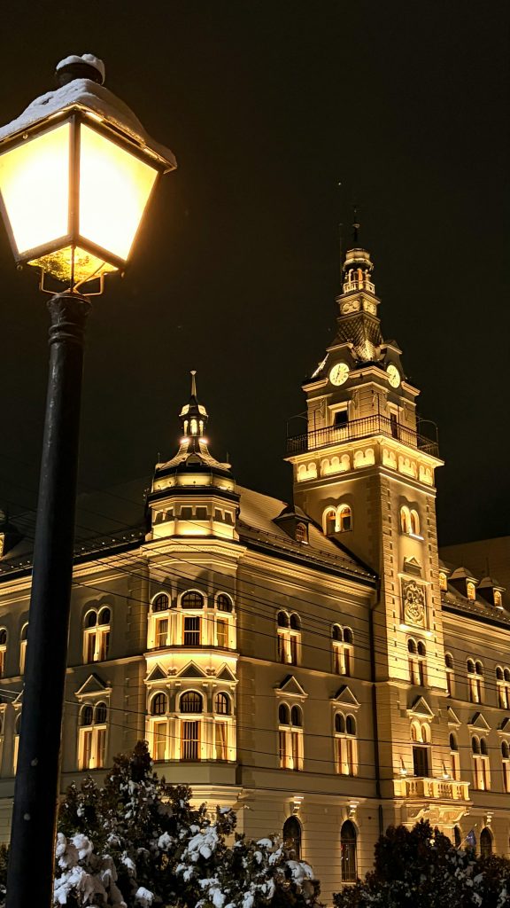 Stunning night view of a vintage building in Suceava, Romania, beautifully lit against the dark sky.