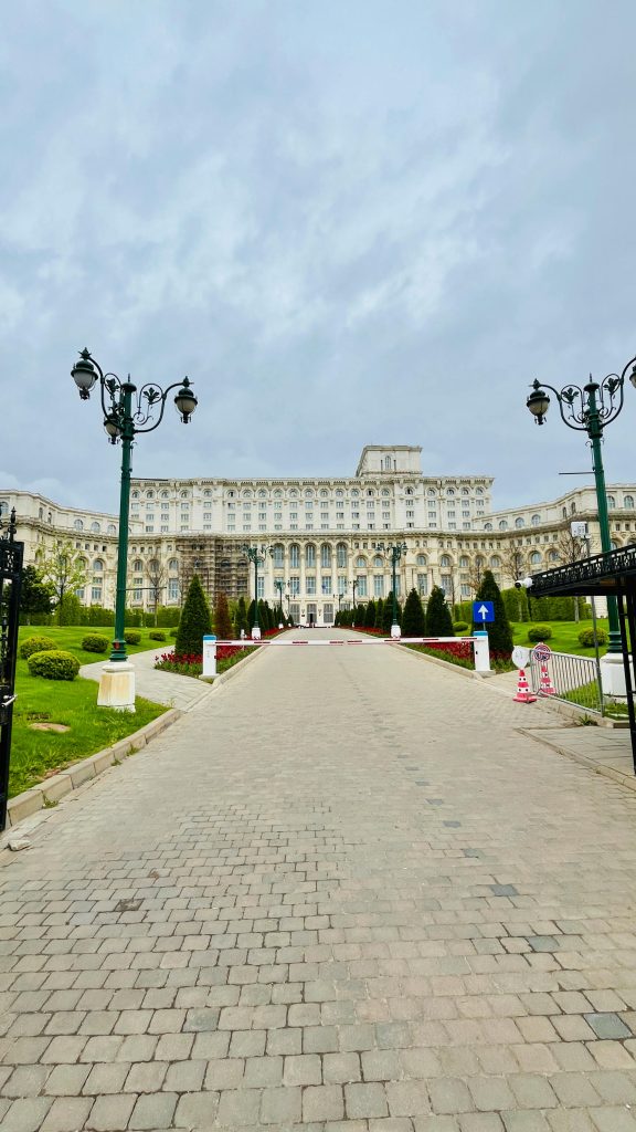 Front view of the Palace of the Parliament in Bucharest, Romania, on a cloudy day.